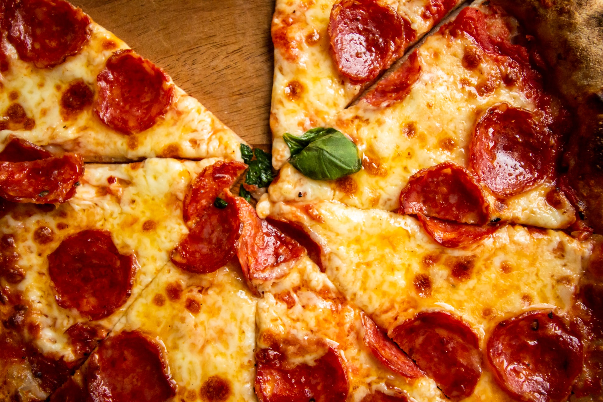 Closeup de pizza de pepperoni con albahaca